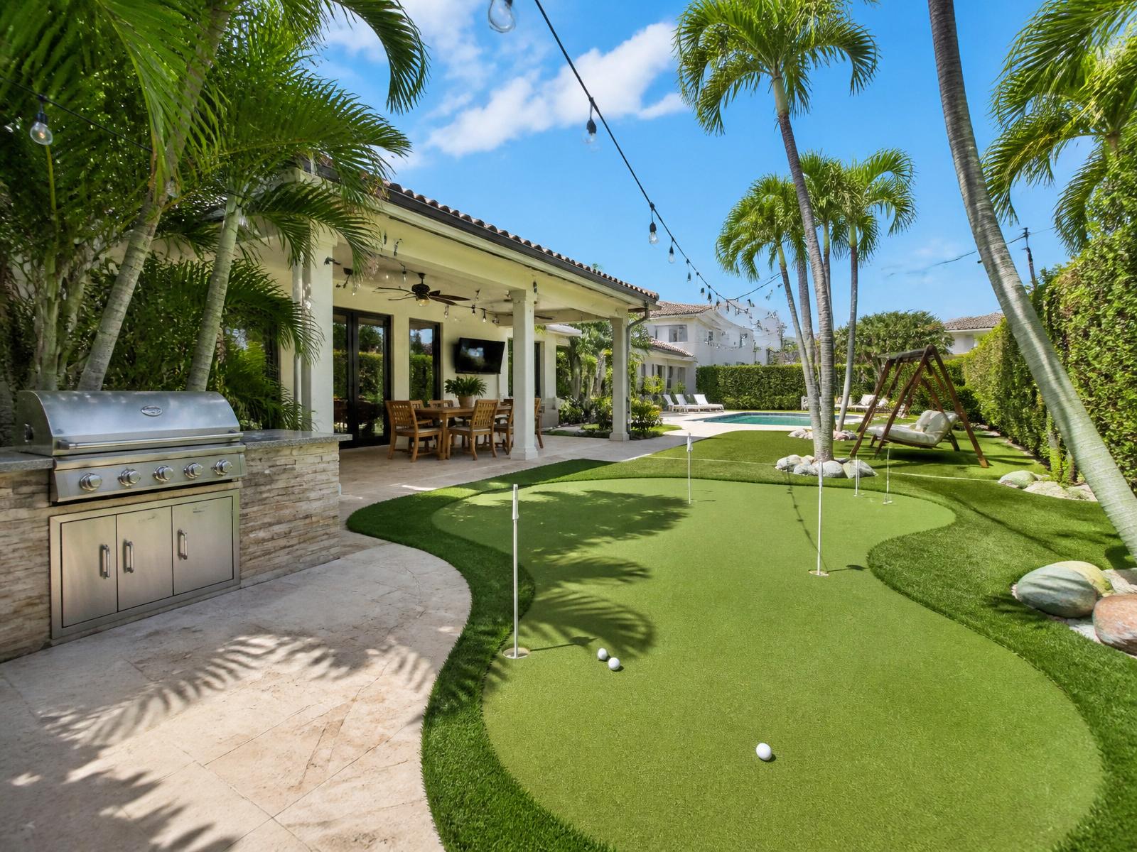 Backyard mini golf and BBQ area with palm trees
